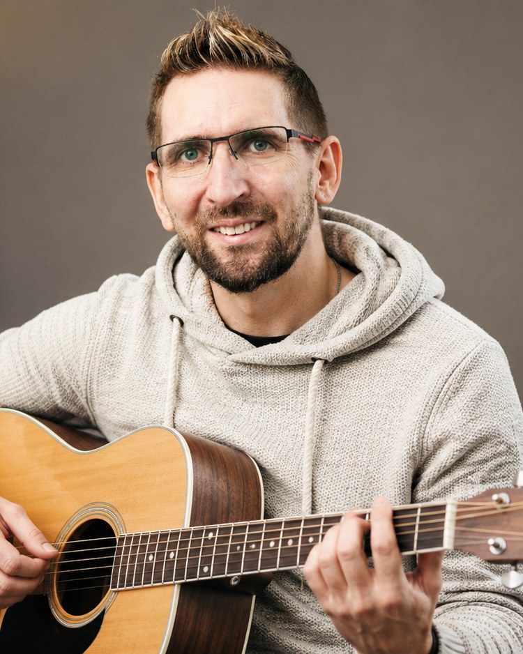 Hände an einer Akustikgitarre im Homestudio